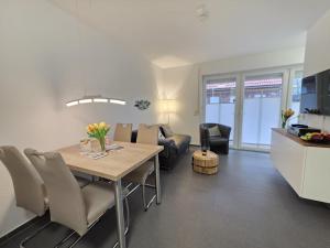 a kitchen and living room with a table and chairs at Ferienwohnung KüstenSAND in Norden