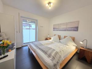 a bedroom with a large bed and a window at Ferienwohnung KüstenSAND in Norden