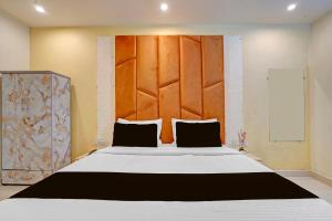 una camera da letto con un letto grande con testiera in legno di Hotel O Ace a Rohtak