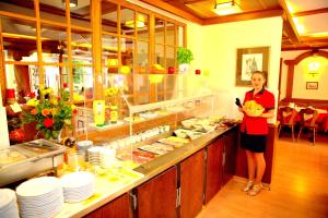 a woman is standing in front of a buffet at Airport Hotel Walldorf in Mörfelden-Walldorf