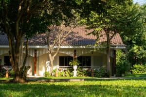 een huis met bomen ervoor bij Comsaed River Kwai Resort in Kanchanaburi