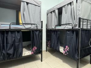 two bunk beds in a room with black curtains at Bed space for Budget Backpacker - No Parking in Abu Dhabi +6 photos