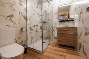 a bathroom with a shower and a toilet at YourHouse Apartamentos Andasol 1D in Chipiona +14 photos