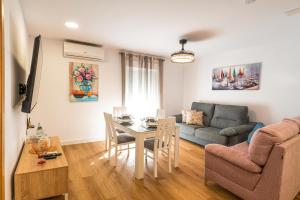 a living room with a table and a couch at YourHouse Apartamentos Andasol 1D in Chipiona