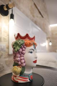 a statue of a woman with vegetables on her head at Pepenero Apulian Rooms in Noci