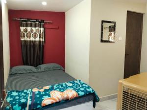 ein Schlafzimmer mit einem Bett und einer roten Wand in der Unterkunft Hegde Farmstay in Udupi