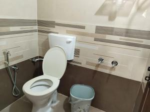 ein Badezimmer mit einem WC und einem Mülleimer in der Unterkunft Hegde Farmstay in Udupi