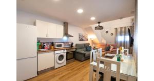 a kitchen and living room with a couch and a table at YourHouse Apartamentos Andasol 1 I in Chipiona