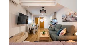 a living room with a couch and a tv at YourHouse Apartamentos Andasol 1 I in Chipiona