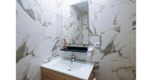 a bathroom with white marble walls and a sink at YourHouse Apartamentos Andasol 1 I in Chipiona +16 photos