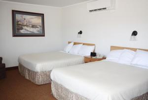 a hotel room with two beds and a picture on the wall at The Bluebird Motel Maine in Machias