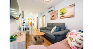 a living room with a couch and a table at YourHouse Apartamentos Andasol BB in Chipiona