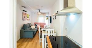 a kitchen and living room with a couch and a table at YourHouse Apartamentos Andasol BB in Chipiona +9 photos