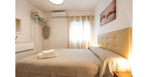 a bedroom with a bed with two towels on it at YourHouse Apartamentos Andasol BB in Chipiona