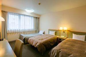 Postel nebo postele na pokoji v ubytování Hotel Sunroute Tochigi