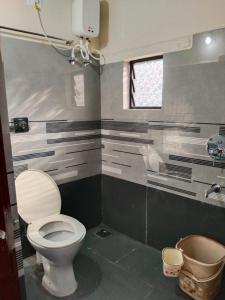 ein Badezimmer mit Toilette und Fenster in der Unterkunft Hegde Farmstay in Udupi