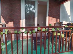 a wooden railing with a table and chairs on a porch at Hegde Farmstay in Udupi