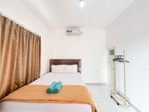una camera da letto con un letto e due pantofole blu sopra di Sofia Residence Syariah Mitra RedDoorz a Malang