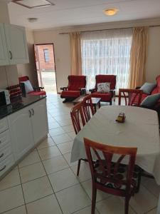 a kitchen and living room with a table and chairs at VSA SELF CATERING unit 1 in Newcastle +10 photos