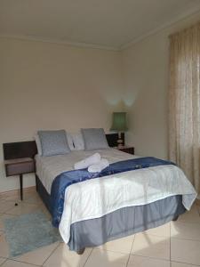 a bedroom with a large bed with towels on it at VSA SELF CATERING unit 1 in Newcastle