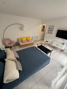 een slaapkamer met een blauw bed en een woonkamer bij Mon Appart avec Terrasse et Piscine in Roquebrune-Cap-Martin