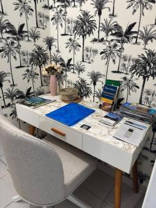 een bureau met een stoel en een muur met palmbomen bij Mon Appart avec Terrasse et Piscine in Roquebrune-Cap-Martin