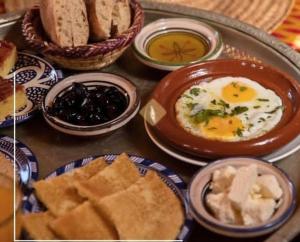een dienblad met eten, eieren, brood en dipsausjes bij Riad Dalal in Fès +58 foto's