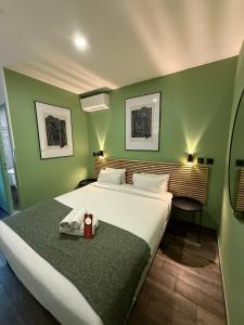 a bedroom with a large bed in a green wall at Hotel de Berne in Nice