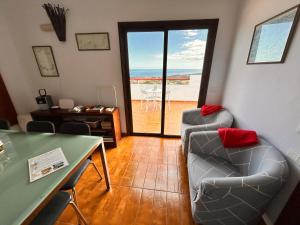 a living room with two chairs and a table with a view at CASA ABUELA MINA in Lomo de Arico