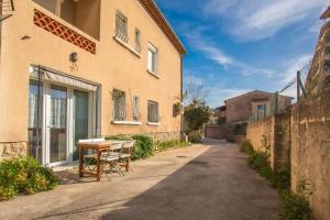 een tafel en stoelen buiten een gebouw bij Studio Clim proche plage et parking in Carqueiranne