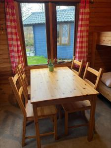 een houten tafel en stoelen in een kamer met een raam bij Camping Suderse - It Sweltsje in Workum