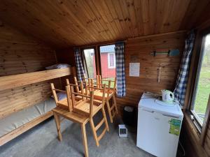 a room with chairs and a refrigerator in a cabin at Camping Suderse - De Protter in Workum