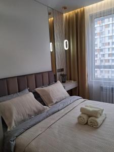 a bedroom with a bed with two towels on it at Rams city квартира in Zhezdi