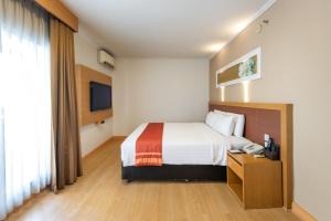 a hotel room with a bed and a television at Maple Hotel in Bangkok +69 photos