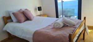 una camera da letto con un letto con cuscini e una finestra di Skyline Villas RC a Calheta