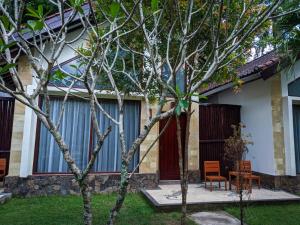 ein Haus mit einem Tisch und Stühlen im Hof in der Unterkunft RaCottage Mandalika in Kuta Lombok
