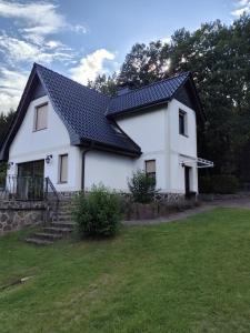 een wit huis met een zwart dak bij Ferienhaus am See in Godendorf