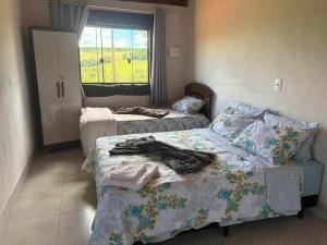 a bedroom with two beds and a window at Recanto Boa Vista - Chalé 1 in São Thomé das Letras