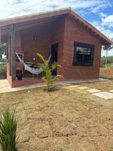 a brick house with a hammock in front of it at Recanto Boa Vista - Chalé 1 in São Thomé das Letras