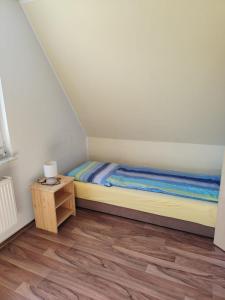 een kleine slaapkamer met een bed en een nachtkastje bij Ferienhaus am See in Godendorf