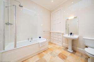 a white bathroom with a tub and a sink at Cleish Apartment in Edinburgh +39 photos