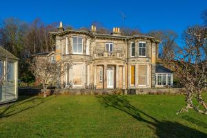 a large stone house with a large yard at Cleish Apartment in Edinburgh