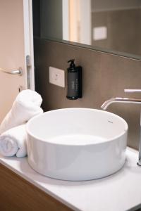 un lavandino bianco in bagno con dispenser di sapone di Balcony Studio Double Suite - Bernina Experience a Tirano