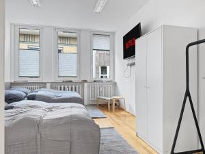 une chambre avec deux lits et une télévision au mur dans l'établissement Stuttgart Sky & Comfort Apartments, à Stuttgart