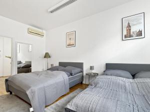 deux lits dans une chambre aux murs blancs dans l'établissement Stuttgart Sky & Comfort Apartments, à Stuttgart 72 autres photos