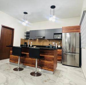 a kitchen with a counter and a refrigerator at Mazatlán Cervo vacacional in Mazatlán