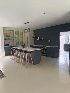 een keuken met zwarte muren en een tafel en krukken bij Tee Off House in Parys