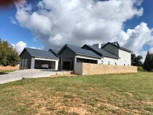 een groot wit huis met een garage bij Tee Off House in Parys