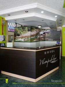 un mostrador de margaritaville de hotel con una gran pantalla en Hotel Wampushkar, en Zamora
