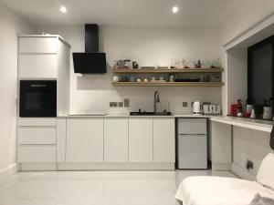 een witte keuken met witte kasten en apparaten bij Letterkenny Town Centre Apartment in Letterkenny +20 foto's
